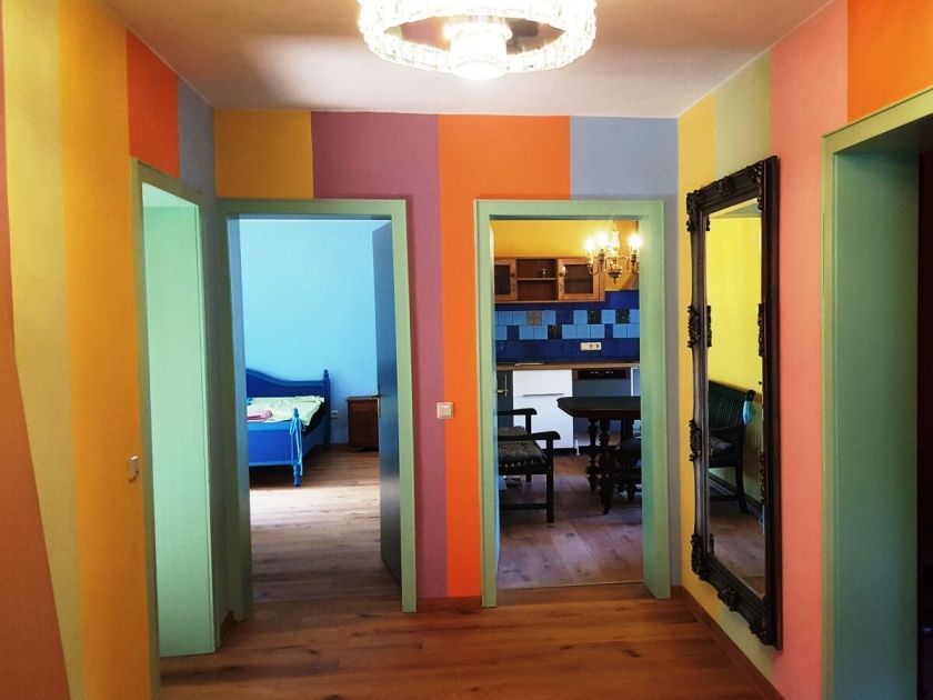 Der Flur spiegelt die Farben der einzelnen Zimmer wieder! Ein großes, blaues Schlafzimmer mit King-Size Doppelbett. Zwei weitere Schlafzimmer.  Eine große Wohnküche mit Terrasse und Moselblick. Das rosa Bad/WC und ein weiteres, getrennetes WC.