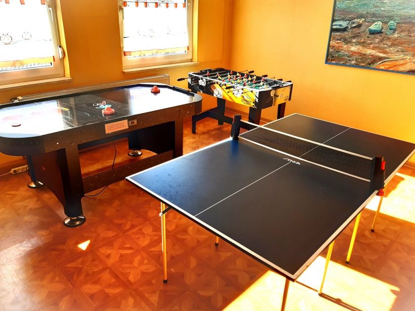 Spielzimmer 1 mit kleinerer Tischtennisplatte, Airhockey und kleinem Kinderkicker